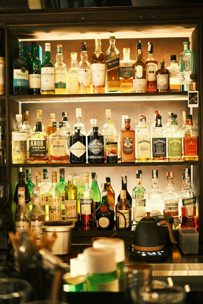 Bar shelves stacked with various alcoholic beverages.